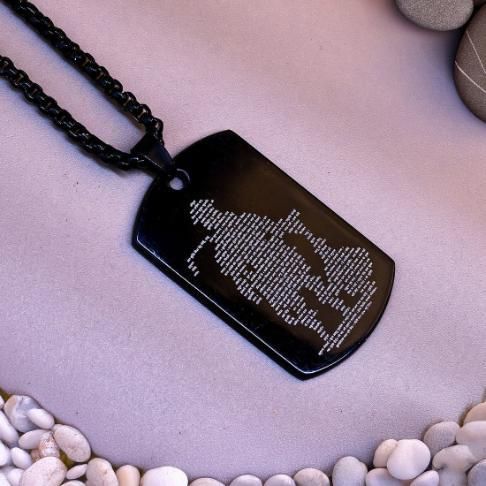 RudraPrana™ Hanuman Chalisa Engraved Divine Protection Pendant on a necklace against a pebble background.